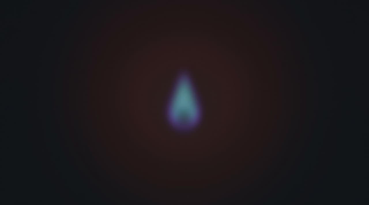 A small blue-green flame-shaped glow in darkness