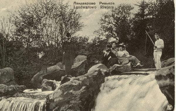 Lentvaris Riviera Postcard, circa 1907 Vintage postcard showing well-dressed people posing on rocks beside a waterfall, captioned Landwarowo Riwjera