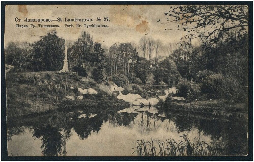 Antique postcard showing a park pond, wooded slope and stone obelisk monument reflected in still water