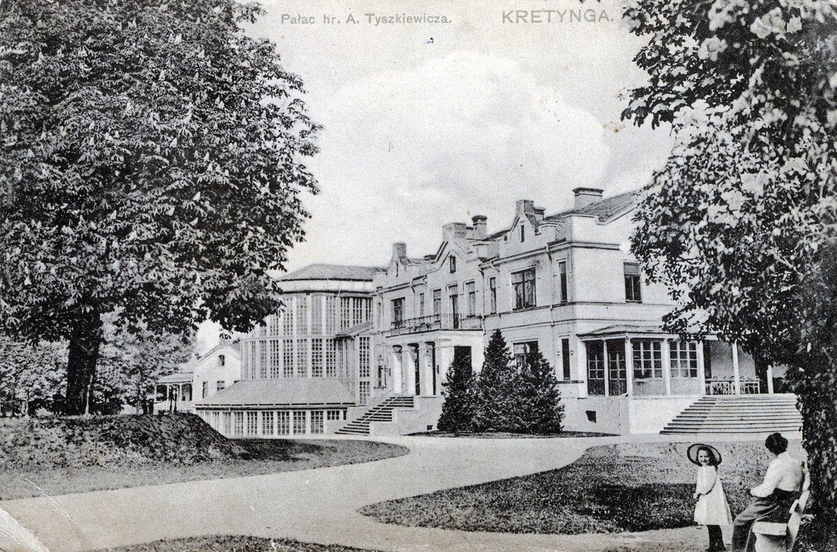 Vintage postcard showing a large white manor house with winter garden, trees and paths, woman and child nearby